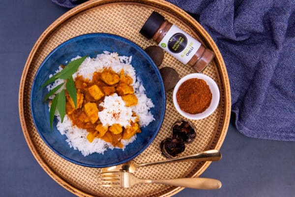 Australian Black Lime chilli shaker with a curry dish